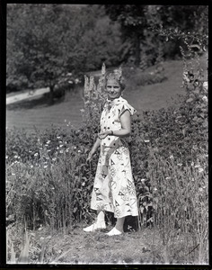 Dorothy Canfield Fisher standing in a garden, by a patch of Monarda