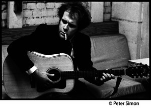 Tim Hardin smoking a cigarette and playing guitar at the Unicorn Coffee House, Boston, Mass.