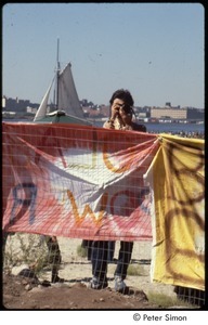 MUSE concert and rally: man taking a photograph behind a fence with banners