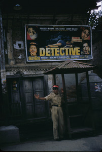 A movie poster decorates a wall near a guard station