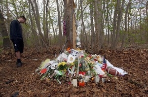 Young man visiting a roadside memorial after a fatal car accident in Barrington, R.I.