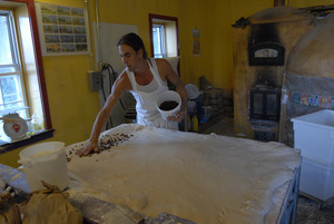 Hungry Ghost Bread: owner and baker Jonathan C. Stevens spreading raisins on dough for cinnamon rolls