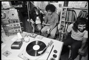 Abbie Hoffman: Hoffman (center) seated at microphone, WBCN studio, holding copy of Steal This Book