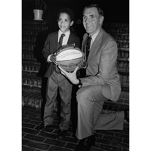 Mayor Raymond Flynn poses with a young boy and a signed basketball