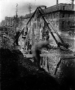 View of workers at construction site at corner of Plympton Street; South End