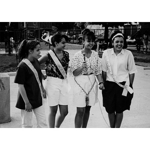 Three teenage girls in the playground with a fourth young woman who is interviewing them.