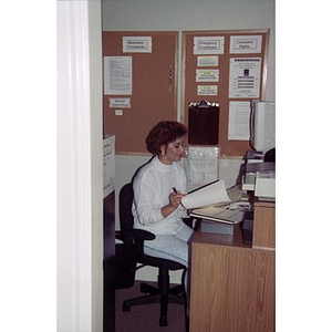 Woman sitting at her desk in her office, possibly at Residencia Betances.