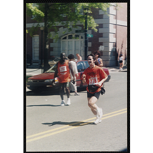 A woman runs past spectators during the Battle of Bunker Hill Road Race