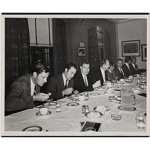 Committee members eat and converse at a Boys' Club event