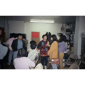 Chinese Progressive Association Director Suzanne Lee, and others, talk to each other after a meeting