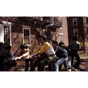 Boys and young men pull on a rope in a game of tug-of-war