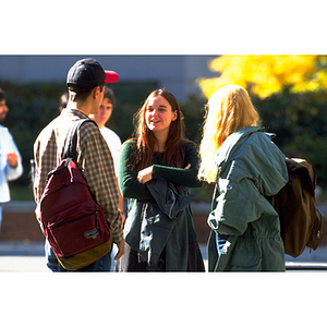 Three students speaking together in the Snell Library courtyard