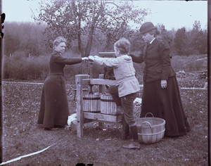 Women and a boy work a cider press, Lancaster, Pennsylvania