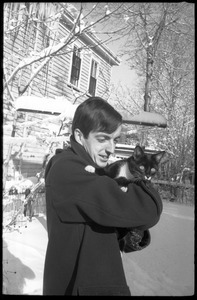 Charles Frizzell holding a tuxedo cat outside after a heavy snow