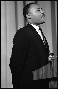 Martin Luther King, Jr., speaking from a podium