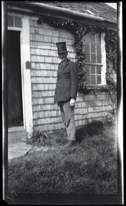 Reuben Austin Snow, the cross-dressing hermit of Cape Cod, wearing a top hat outside the cottage