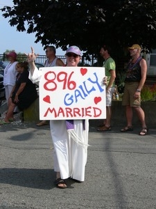 Parade marcher with sign celebrating same sex marriage, reading '896 gaily married' : Provincetown Carnival parade