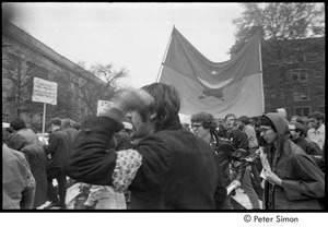 MIT war research demonstration: demonstrators marching with signs and an NLF flag