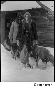 Catherine Blinder in heavy winter coat, with masked communard [Elliot Blinder] and dogs, walking in heavy snow, Tree Frog Farm commune