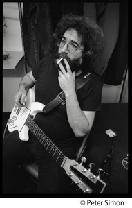 Jerry Garcia: half-length portrait with guitar, smoking a cigarette