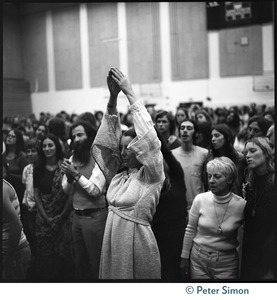 Woman in the audience stretching during the appearance by Ram Dass at Sonoma State University