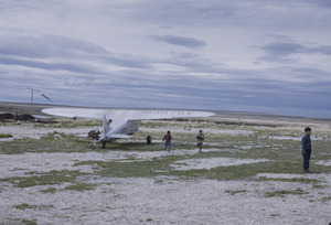 Eskimo children running after airplane taking off
