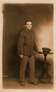 Ignacy Skarpetowski in First World War uniform: full-length studio portrait with hand and hat on side table