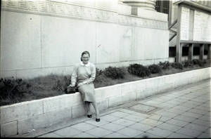 A woman sitting on a low wall