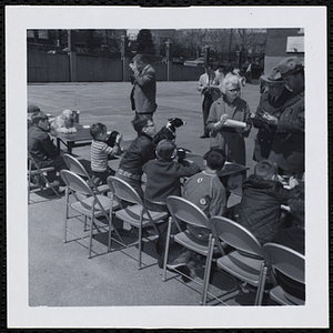 Three judges converse in front of the participants sitting with their pets at a Boys' Club Pet Show