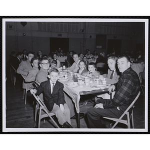 Men and boys sit at a table during a Dad's Club banquet