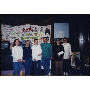 Jerry Steimel stands with several adults and youth for a group photo during an open house