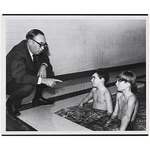 "Advertising Executive Kenneth D. Clapp (left) of Humphrey Browning MacDougall Inc., and South Boston Boys' Club swim team members, Michael Pyne and Joe Watts, talk about the clubs' recreational programs for inner city youth"