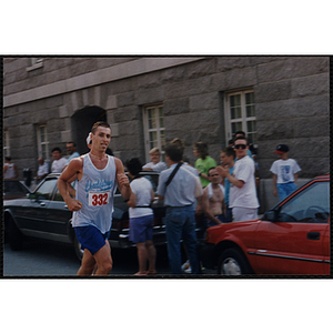 A man runs by a group of spectators during the Bunker Hill Road Race