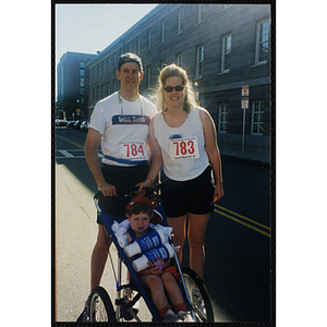 A man and a woman pose with a boy in a stroller at the Battle of Bunker Hill Road Race