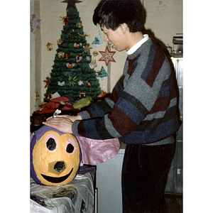 Man finishing a piñata before the Chinese Progressive Association's children's party