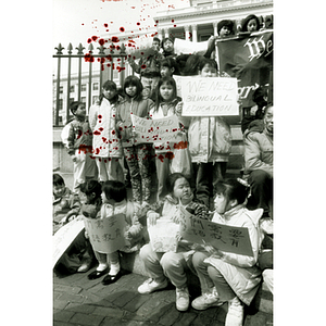 Chinese American children hold protest signs at a rally outside the Massachusetts State House for bilingual education