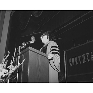 Professor Raymond Robinson speaks at a podium on Honors Day