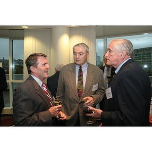 Three men converse over drinks at the Veterans Memorial dinner