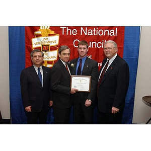 An unidentified inductee poses with his certificate and three others at the National Council Dinner