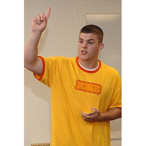 Joseph Bordieri gestures while speaking at the Torch Scholars talent show