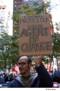 Occupy Wall Street: man holding sign reading, 'I am not a protestor, I am an agent of change'