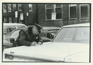 Unidentified police officer writing parking ticket