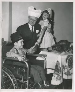 George Jessel in chef's hat with young clients in Thanksgiving costume