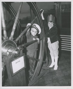 Boy and girl in wheelhouse on boat ride