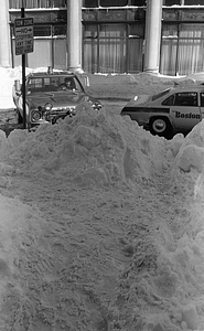 Snowdrifts, car, and Boston police cruiser on Berkeley and Stuart Streets