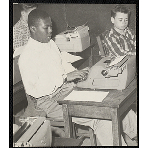 Three boys participate in a typewriting class