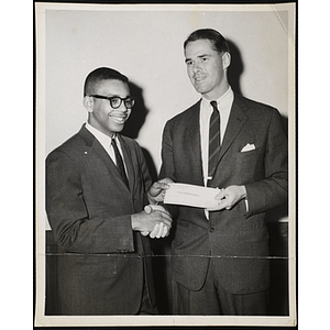 Frederick S. Moseley III, Overseer of the Boys' Clubs of Boston, at right, presents the Boy of the Year Award to an unidentified young man and shakes his hand
