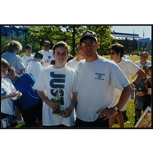 Executive Director Jerry Steimel poses with a girl holding a trophy during the Battle of Bunker Hill Road Race