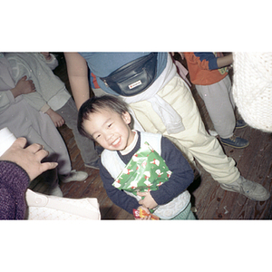 Boy holds a present and candy at the Chinese Progressive Association's celebration of the Lunar New Year