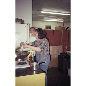 Woman smiling and talking to a man as she cooks in a kitchen